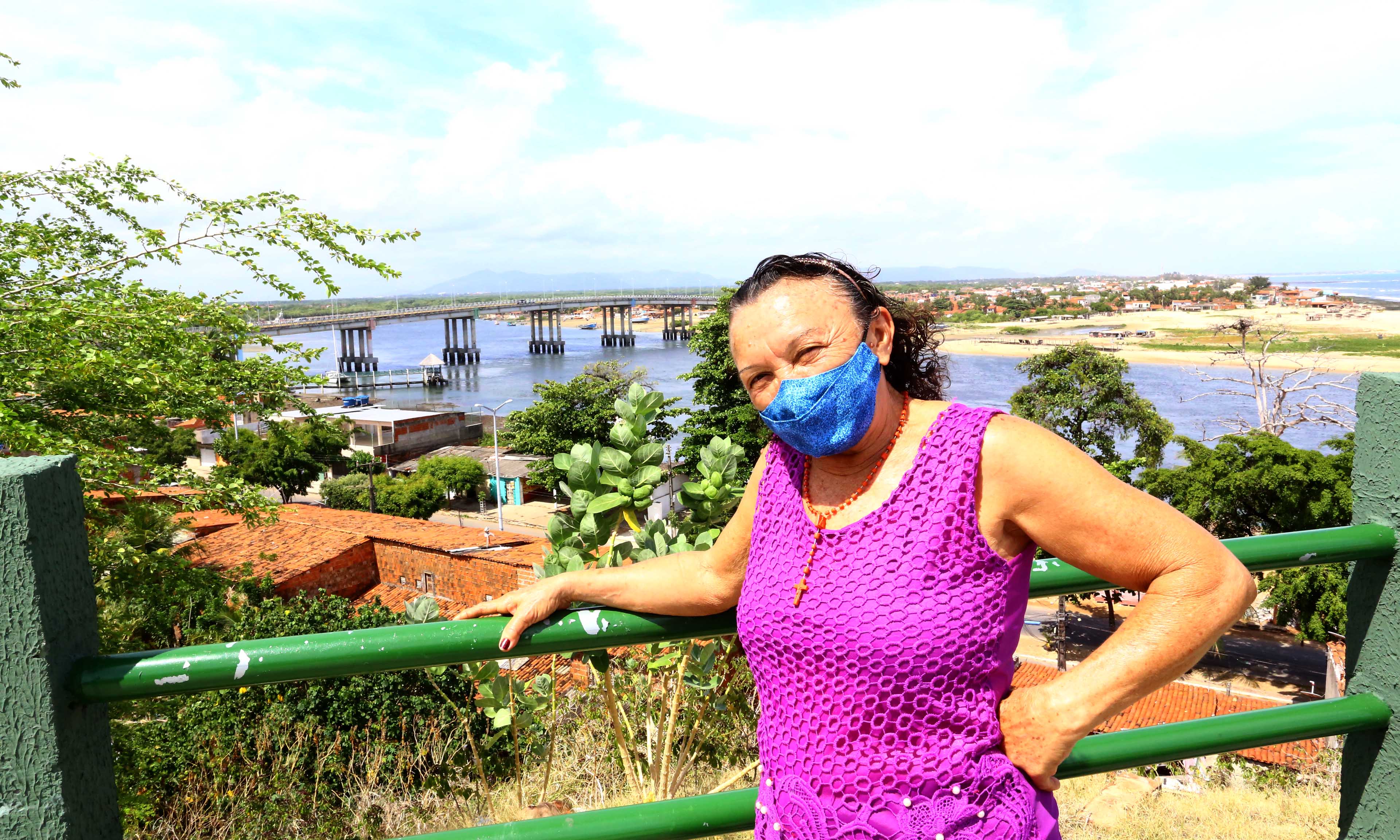 mulher de máscara posa em um mirante